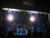 Senior i el Cor Brutal amb membres d�Arthur Caravan a l�escenari de la Llotja d�Elx. Fotografia: Jeroni Rico